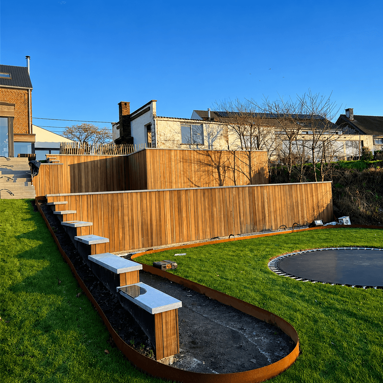 Jardin en plusieurs niveaux avec retenue de terre et palissade